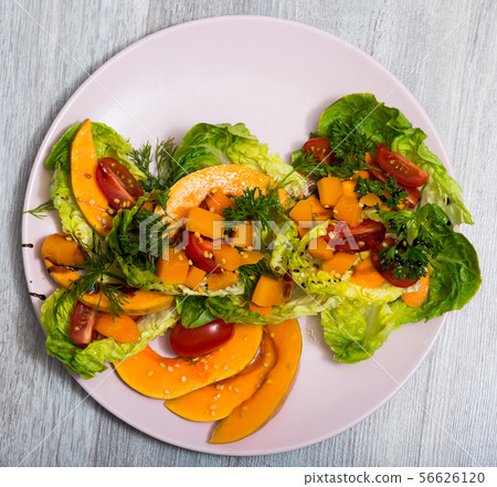 Salad of baked pumpkin, cherry tomatoes, sesame, sauce and greens Salad of baked pumpkin, cherry tomatoes, sesame, sauce and greens 56626120
