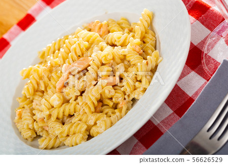 Close up of tasty warm pasta with smoked salmon at plate on table Close up of tasty warm pasta with smoked salmon at plate on table 56626529