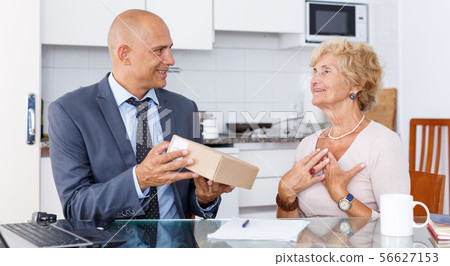 Man demonstrating cardboard box woman Man demonstrating cardboard box woman 56627153