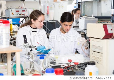 Scientists noting results of research in test chart 56627533