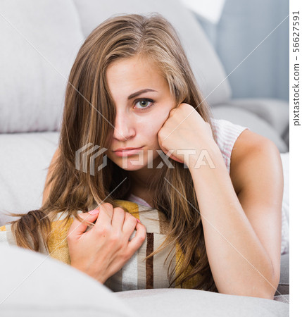 Sad woman on sofa with pillow 56627591