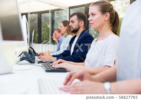 Side view of row of attentive people working Side view of row of attentive people working 56627765
