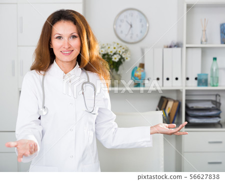 Portrait of female doctor who is working and posing on her workplace 56627838