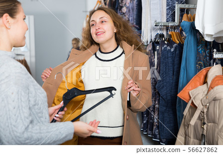Woman trying new coat in showroom 56627862