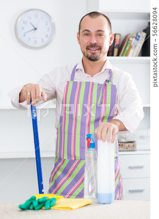 Young man in apron cleaning table Young man in apron cleaning table 56628094