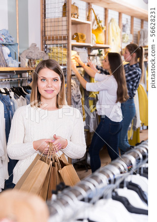 Young woman carrying paper bags with purchases in fashion store 56628231