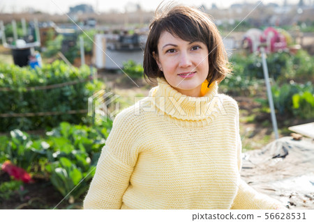 Girl in a yellow sweater in the backyard of her cottage Girl in a yellow sweater in the backyard of her cottage 56628531