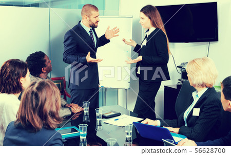 Manager expressing his dissatisfaction to female colleague during office meeting 56628700