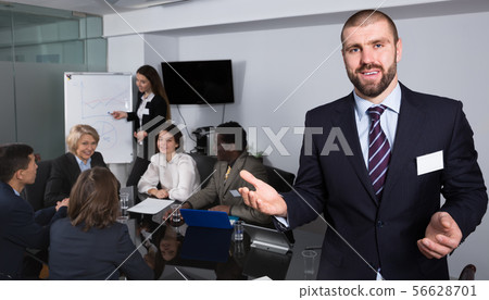 Man inviting to modern meeting room with business people Man inviting to modern meeting room with business people 56628701