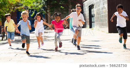 Group of joyful children running down the city street 56628730