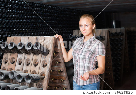 female wine maker in winery cellar. female wine maker in winery cellar. 56628929