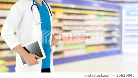 Pharmacist using tablet computer at pharmacy. Pharmacist using tablet computer at pharmacy. 56629043