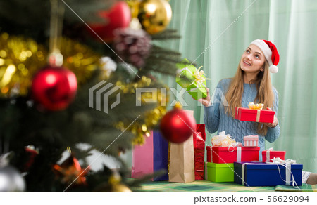 Girl with X-mas presents at home. 56629094