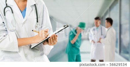 Doctor working in hospital with other doctors. 56629534
