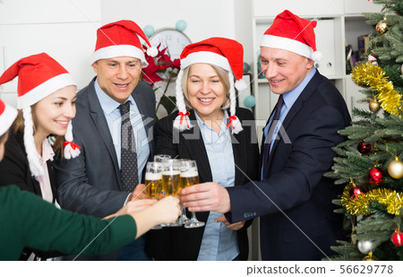 Happy business group people in santa hat at Xmas corporate party Happy business group people in santa hat at Xmas corporate party 56629778