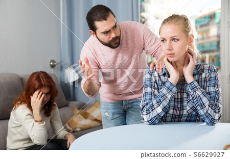 Young spouses and mother-in-low arguing indoors Young spouses and mother-in-low arguing indoors 56629927