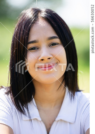 Positive young brazilian female portrait in summer garden 56630052