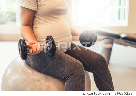 Active pregnant woman exercise in fitness center. Active pregnant woman exercise in fitness center. 56630238