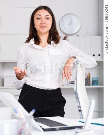 Girl manager standing and welcoming to office at table 56630241