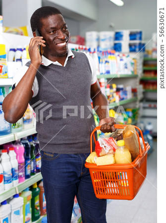 Man talking by phone in grocery 56630671