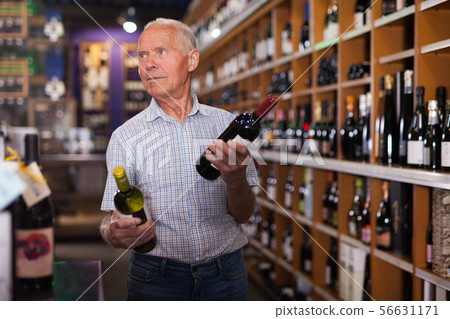 Man searchng wine in winehouse 56631171