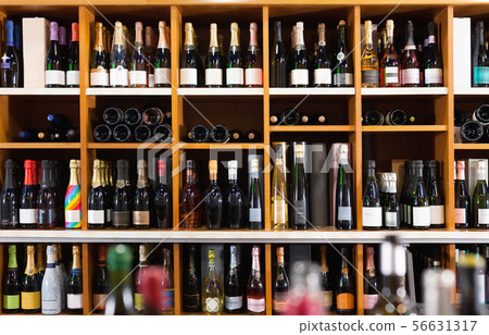 Rows of wine bottles on shelves in modern wine store waiting for customers 56631317