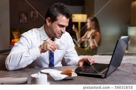 Man drinking coffee and working with laptop 56631658
