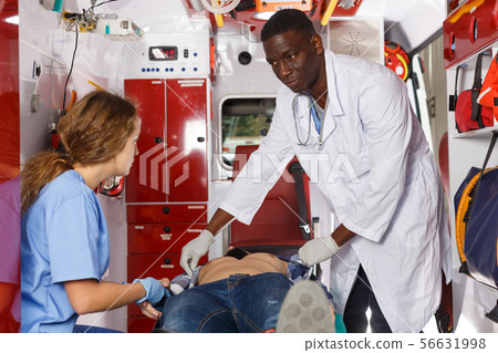 Paramedic team providing first aid to man 56631998