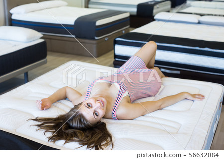 Positive sexy woman lying on soft mattress 56632084