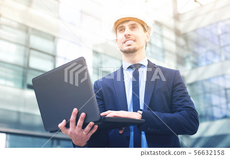 Portrait of positive man builder work at the laptop Portrait of positive man builder work at the laptop 56632158