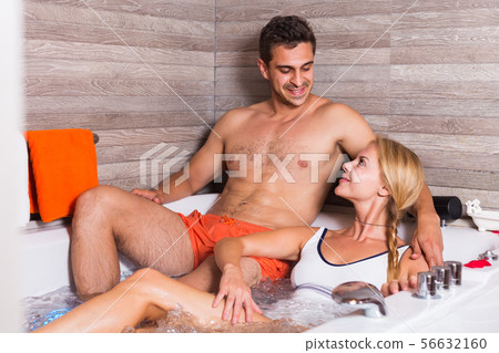 Young male with female are talking in bath with red petals Young male with female are talking in bath with red petals 56632160