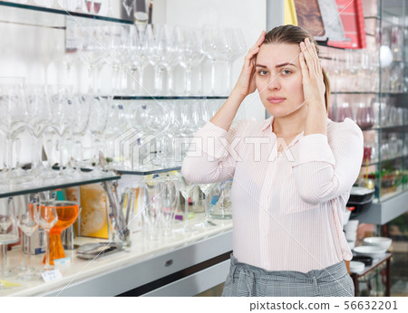 Adult worried female customer choosing wineglass 56632201