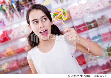emotional schoolgirl standing with lollipop 56632219