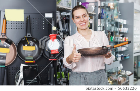 Young housewife is choosing new stewpot for her kitchen 56632220