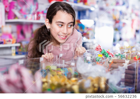 Emotional small girl choosing sweet candies in the candy shop Emotional small girl choosing sweet candies in the candy shop 56632236