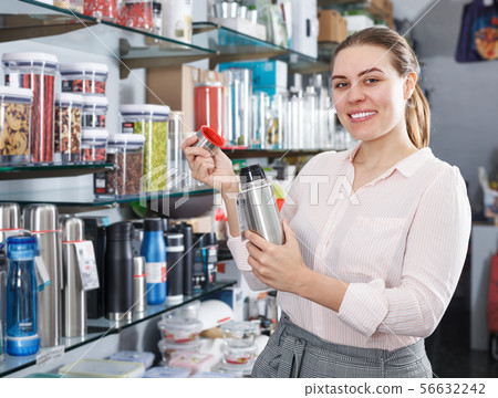 Young woman customer choosing ware for wine bottle Young woman customer choosing ware for wine bottle 56632242