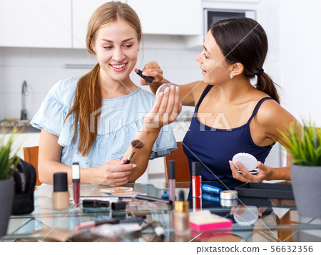 Women friends talking and applying make up 56632356