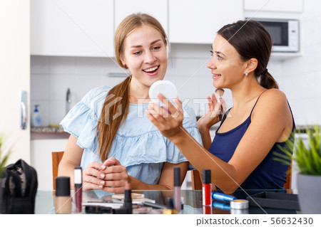 Women friends talking and applying make up Women friends talking and applying make up 56632430