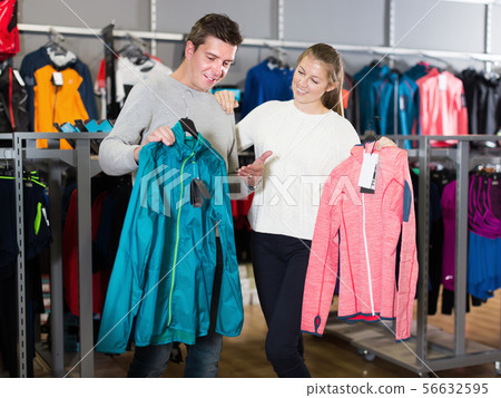 Young couple in sports shop choosing sport clothes 56632595