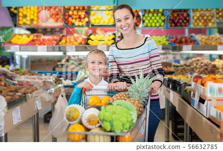 Portrait of happy woman and her little son with shopping cart full of fruits and vegetables Portrait of happy woman and her little son with shopping cart full of fruits and vegetables 56632785