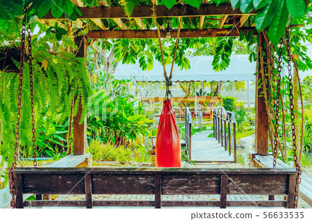 Red sand bag for Muay Thai hanging in the garden 56633535