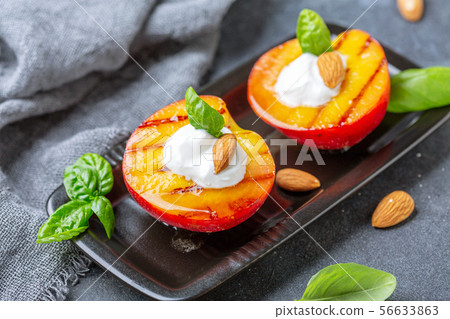 Fried peaches with yogurt, honey and almonds. 56633863