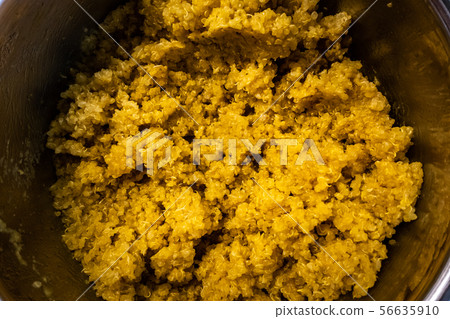 cooked steamed orange quinoa grits in a pan close up 56635910