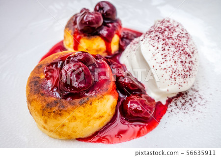 cottage cheese pancakes with sour cream on white plates 56635911