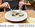 girl eating sweet potato pancakes with knife and fork 56635934