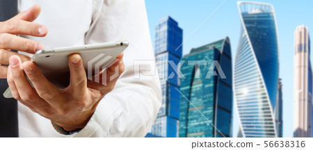 Businessman using tablet computer over cityscape background 56638316
