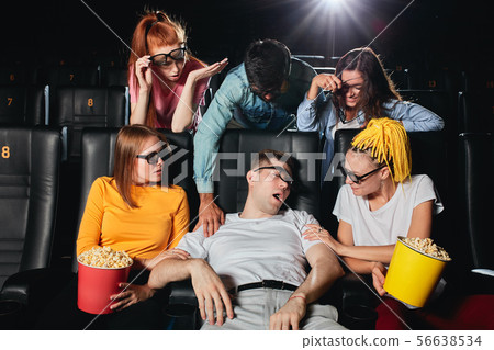 sleeping young man in 3d glasses disturbing his friends during the session 56638534