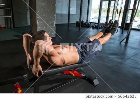 A muscular male athlete doing workout at the gym A muscular male athlete doing workout at the gym 56642625