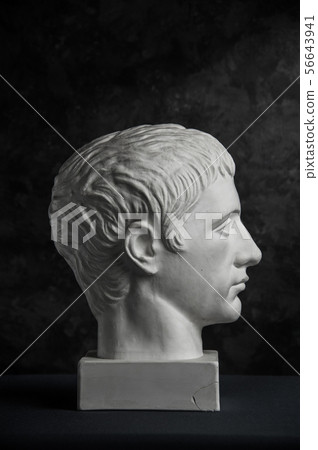Gypsum copy of ancient statue Germanicus head on dark textured background. Plaster sculpture man 56643941