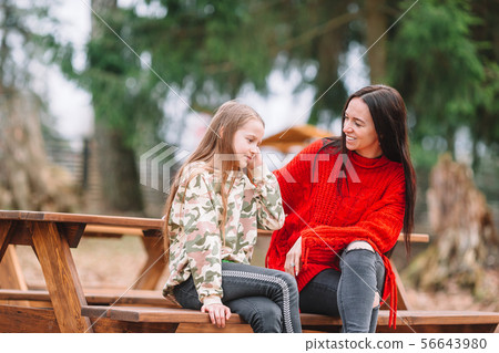 Mother and daughter playing with dog outdoors Mother and daughter playing with dog outdoors 56643980